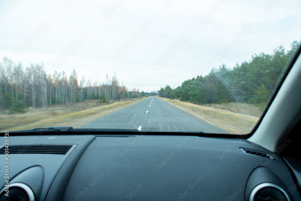 view of the road from the window of a moving car.