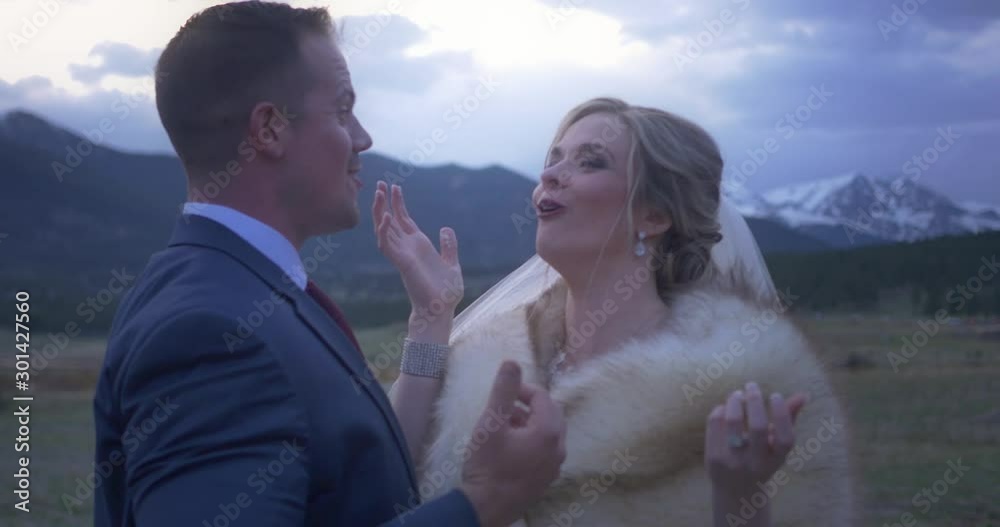 A bride and groom feed each other cake and giggle at their winter mountain wedding A bride and groom feed each other cake and giggle at their winter mountain wedding