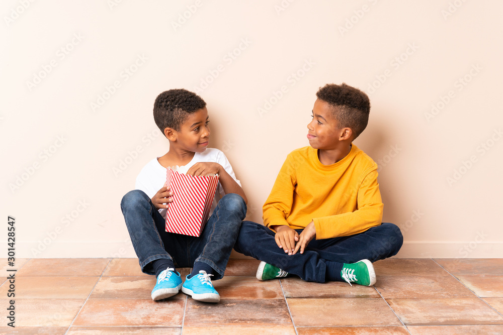 African American brothers holding popcorns African American brothers holding popcorns