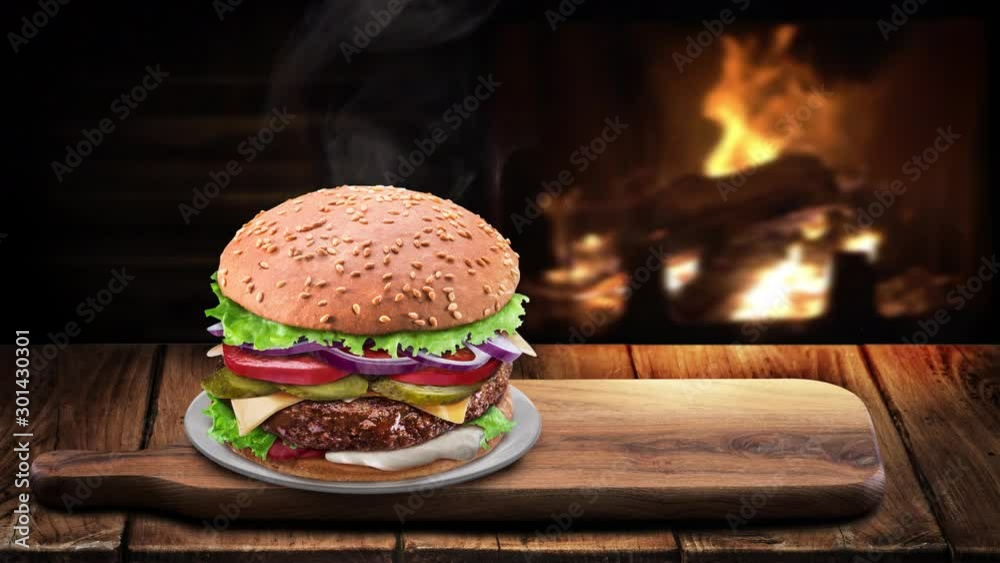 Fresh hot hamburger on an old vintage table. Steam rises above the product, behind a wooden wall and a burning fireplace.