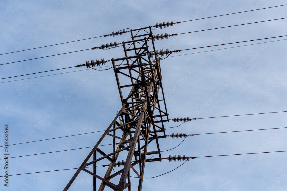 Rusty power line is on the blue sky background