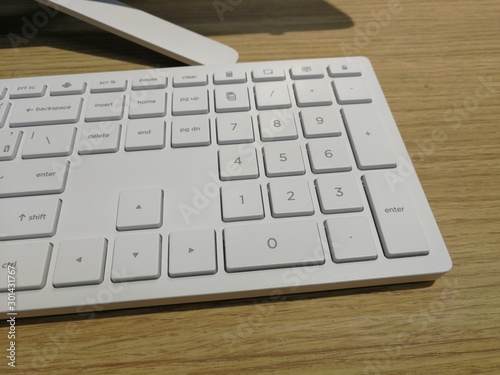 White keyboards on wooden background.