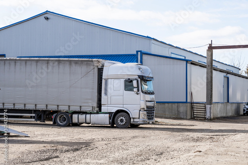 Modern trucks of various colors and models are involved for the transportation of different kinds of commercial goods are in a row on truck stop in anticipation of the continuation of working flights.