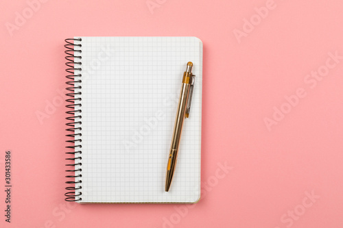 the white open notepad isolated on the pink background