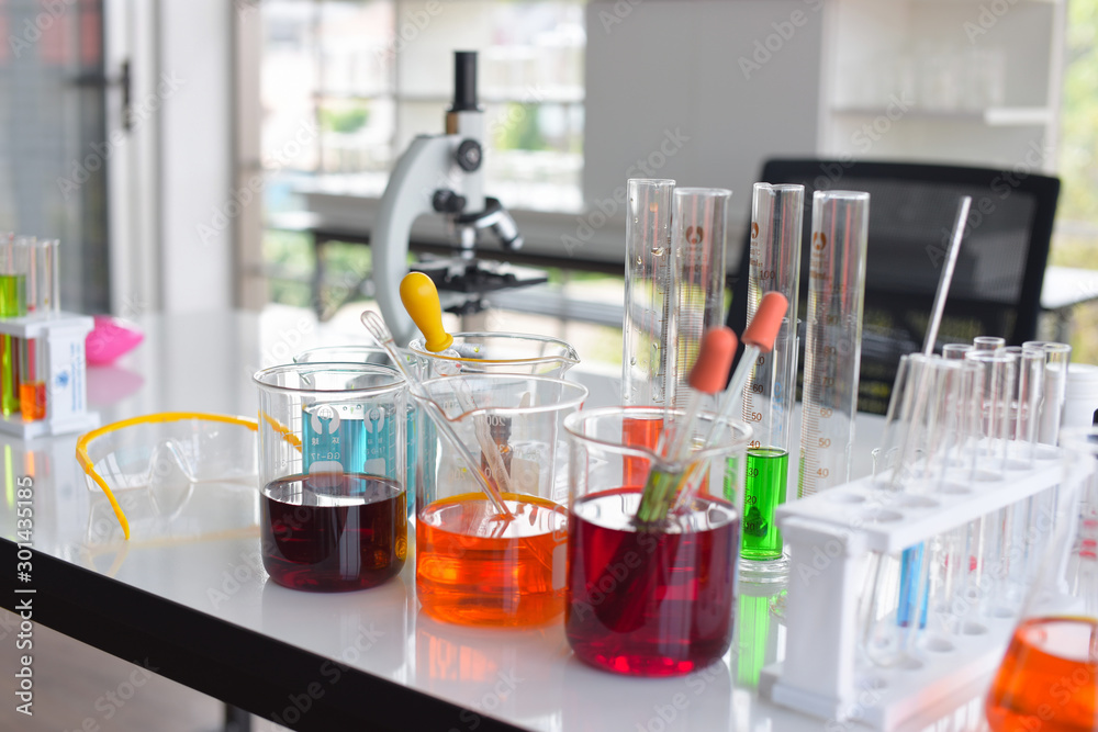 glass test tubes and flasks with colorful liquid on blue background with molecular structure glass test tubes and flasks with colorful liquid on blue background with molecular structure
