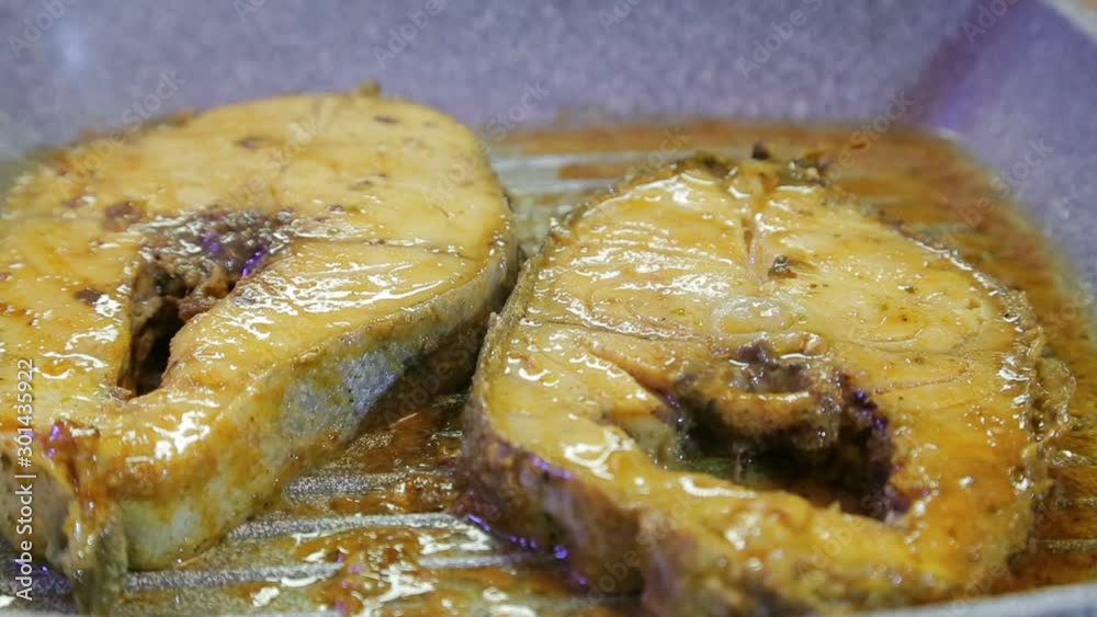 Fish steaks grilling in oil and sauce. Close-up Fish steaks grilling in oil and sauce. Close-up