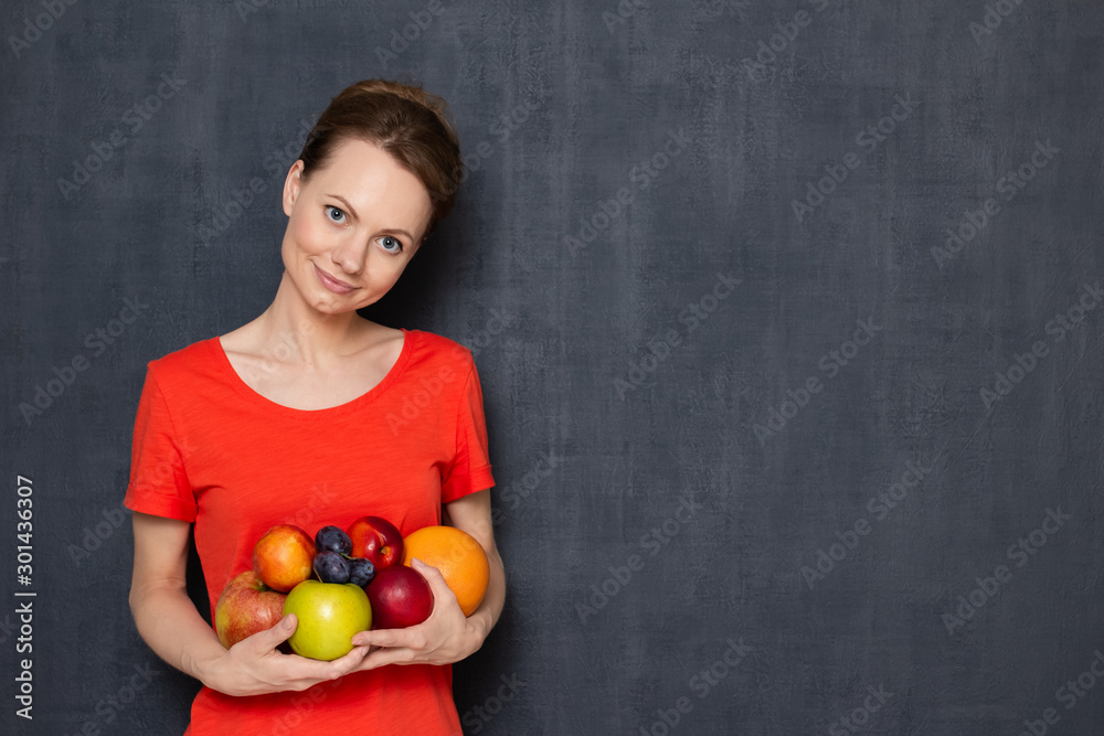 Portrait of happy young woman holding ripe fresh fruits in hands Portrait of happy young woman holding ripe fresh fruits in hands