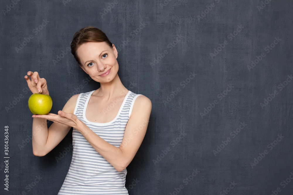 Portrait of happy young woman holding ripe apple in hands Portrait of happy young woman holding ripe apple in hands