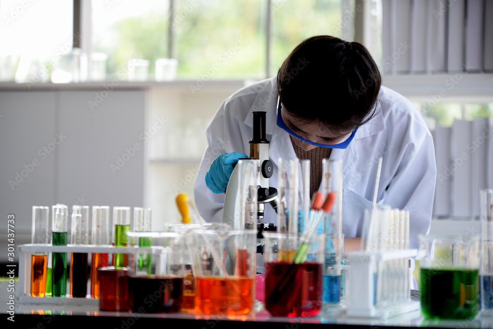 Scientists are working in science labs.Close-up of a scientistYoung female scientist looking through a microscope in a laboratory doing research