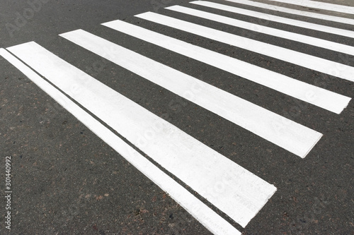Road marking on asphalt with direction of movement and pedestrian crossing