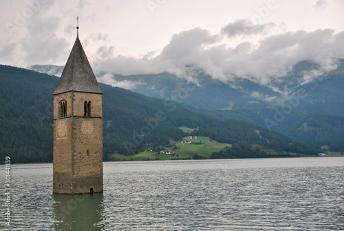 Resia lake with its bell tower in a cloudy day