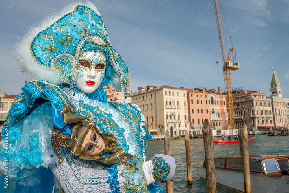 femme costumé de bleu et de blanc devant le grand canal au carnaval di Venise en Italie 