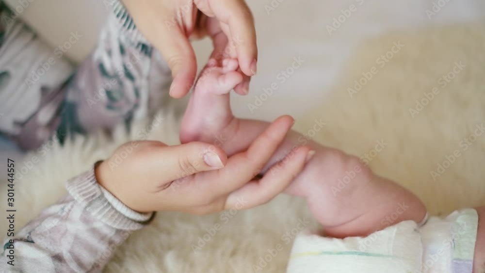 mother strokes her newborn baby's feet. Massage baby feet mother strokes her newborn baby's feet. Massage baby feet