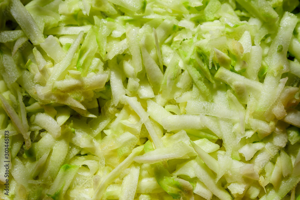 Fresh organic green grated zucchini on table, top view or flat lay of tasty healthy food photographed with soft focus Fresh organic green grated zucchini on table, top view or flat lay of tasty healthy food photographed with soft focus