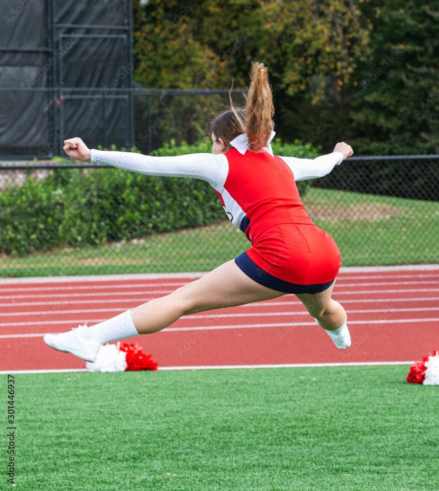 Cheerleader jumping in air while practicing before performance