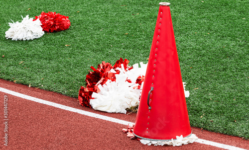 Red and white cheerleading megaphone and pop poms photo