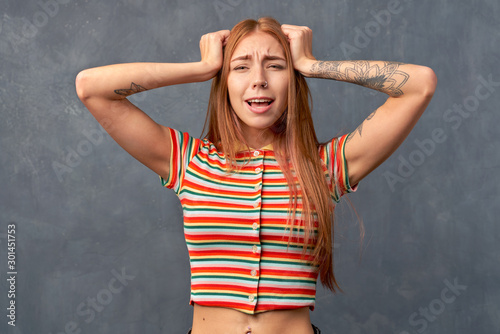 Young desperate annoyed woman keeps hands on head