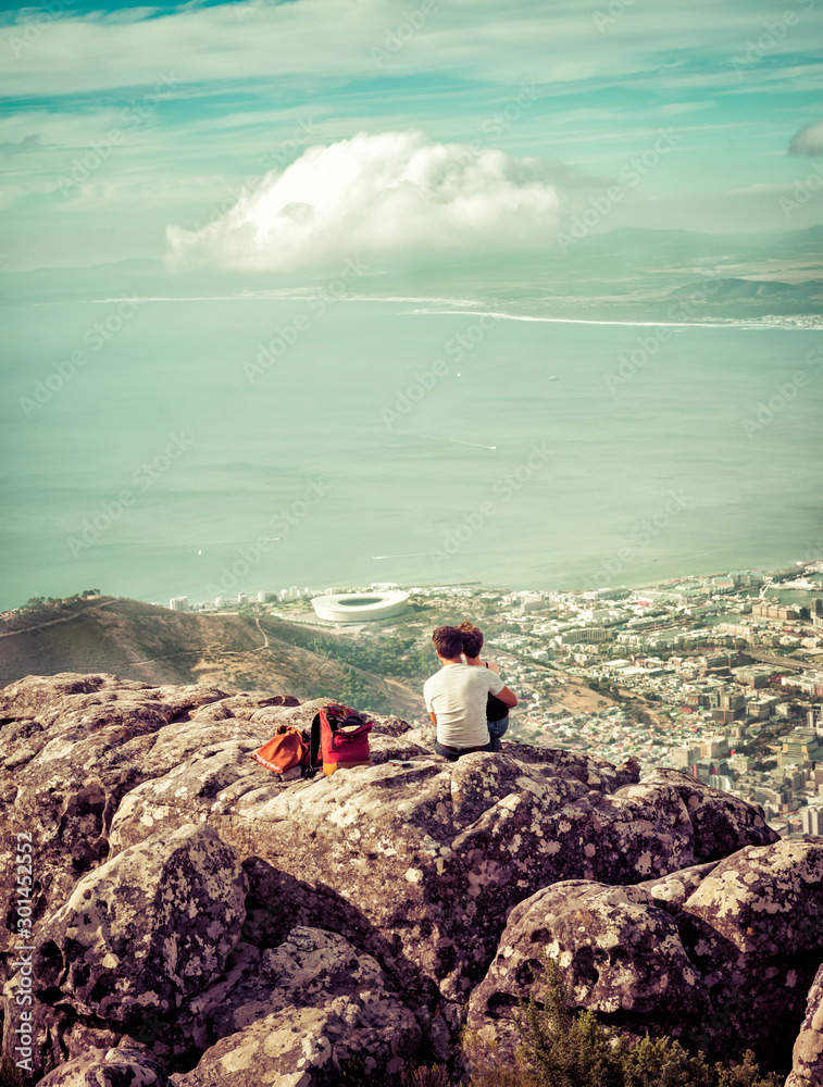 Couple in Love Sitting on Top of Mountain Rocks Looking at View