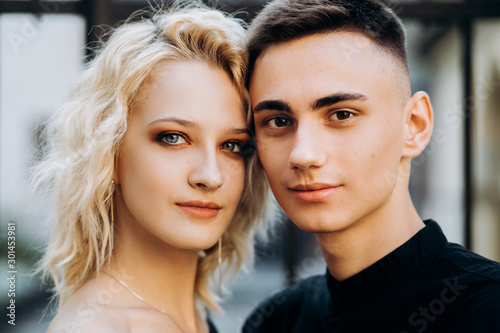 Portrait of face of loving couple. Sweet blonde with wavy hair and a brunette guy