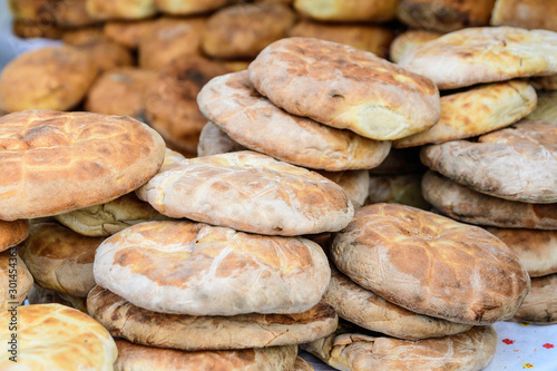 Heap of freshly baked whole-grain bread displayed for sale at a street food market, healthy food photographed with soft focus