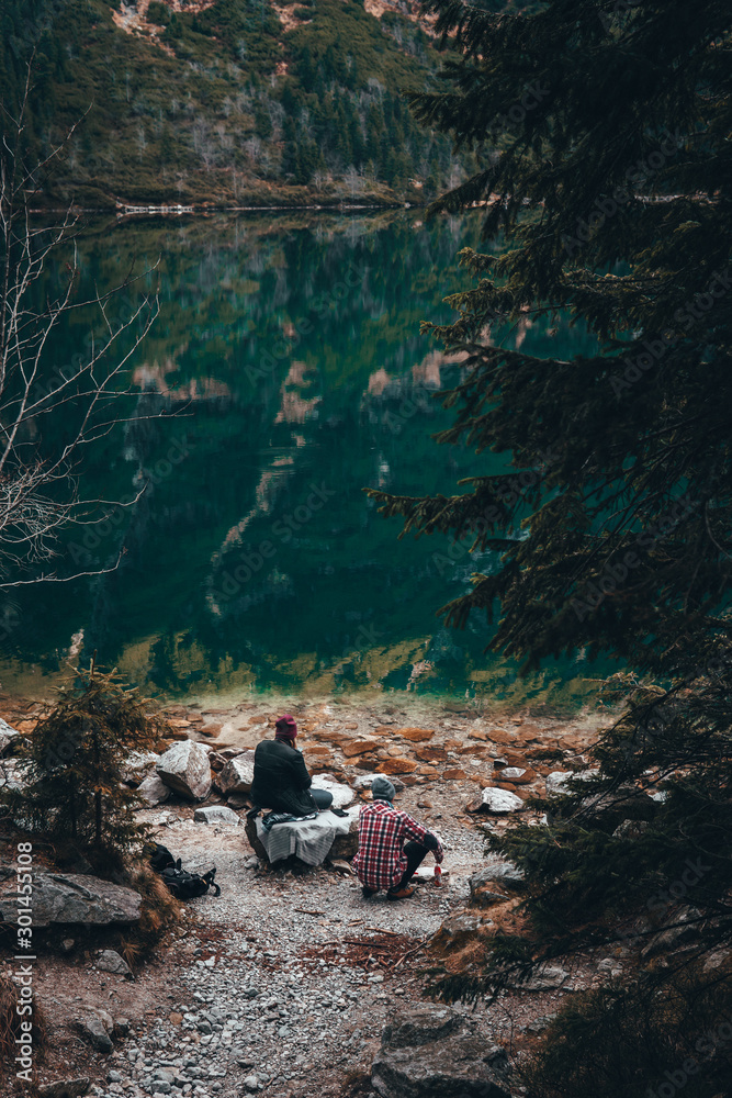 Personas disfrutando de la naturaleza en un lago en la montaña con bosque  foto de Stock | Adobe Stock