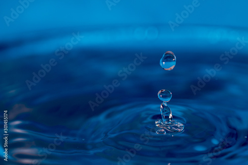 water drop splash in a blue colored glass 