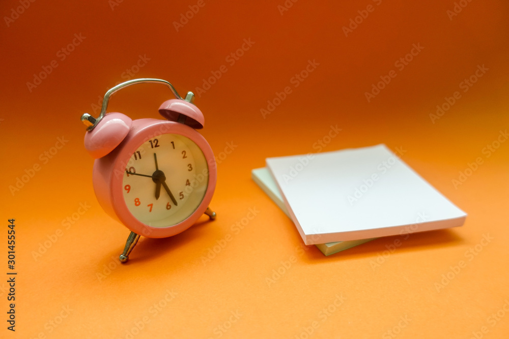 Alarm Clock And Adhesive Note Over Orange Background Alarm Clock And Adhesive Note Over Orange Background