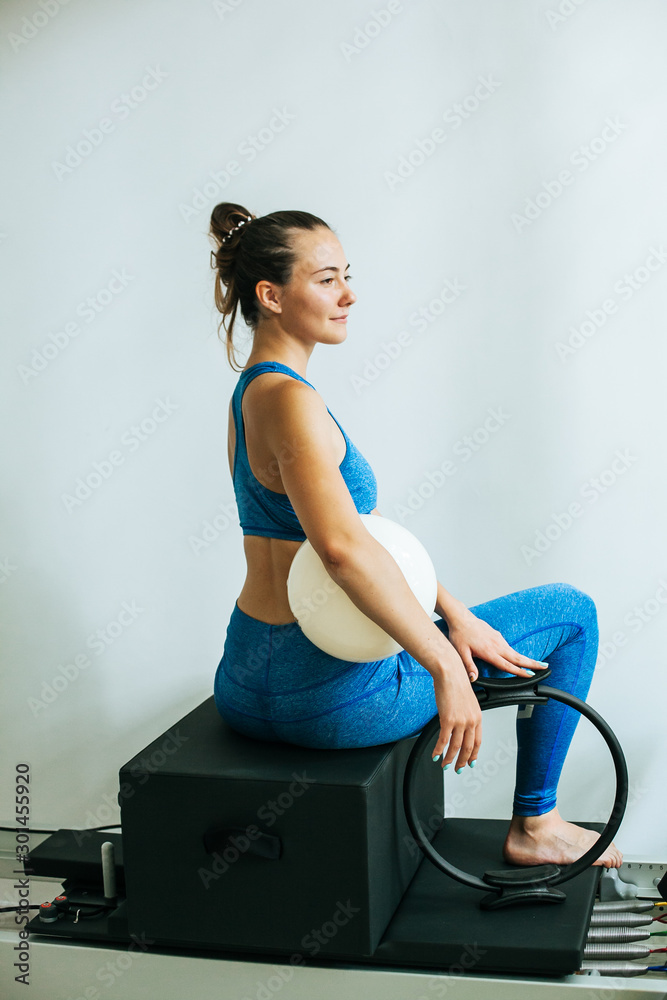 Woman performing Pilates exercise using a Cadillac or Trapeze table