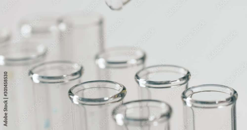 Close up of pipette with liquid inside and water drop in test tubes. Science concept. Close up 4k footage. Close up of pipette with liquid inside and water drop in test tubes. Science concept. Close up 4k footage.