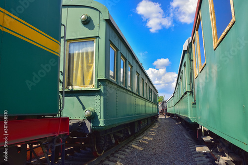 between cars of vintage trains, between two old trains, old green wagons photo