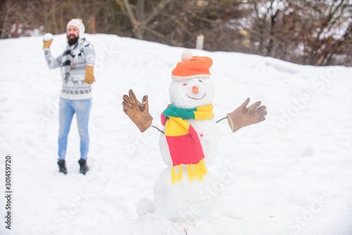 I cant believe in it. man play with snow. winter season activity. its christmas. bearded man build snowman. winter holiday outdoor. warm sweater in cold weather. happy hipster ready to celebrate xmas