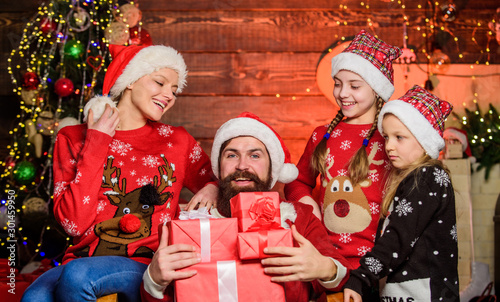 Good Gifts. Happy family celebrate new year and Christmas. cheerful mother love children. open xmas present. gifts from santa. small girls sisters with parents. santa father at decorated tree