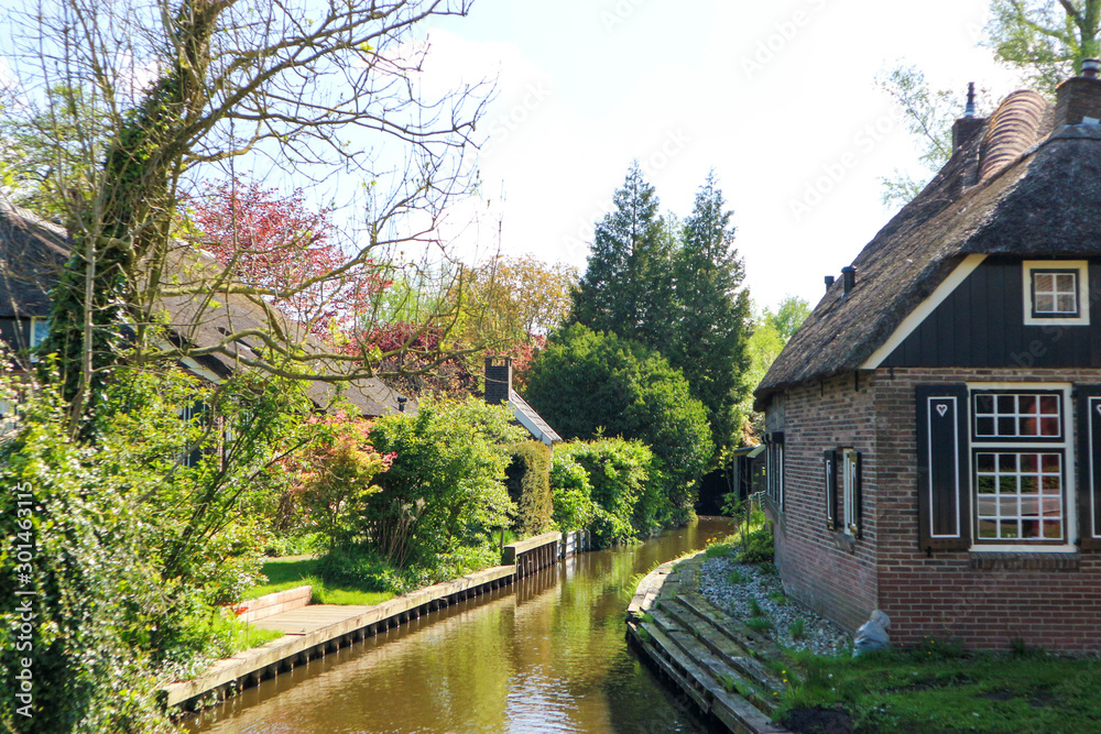 Small canal in Netherlands in sunny spring day, Giethoorn Small canal in Netherlands in sunny spring day, Giethoorn