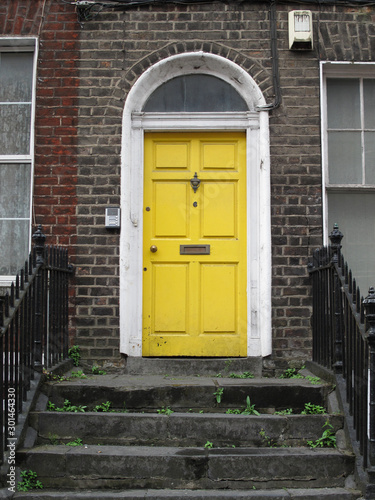 Lovely yellow door of a building in Georgian style in Limerick, Ireland