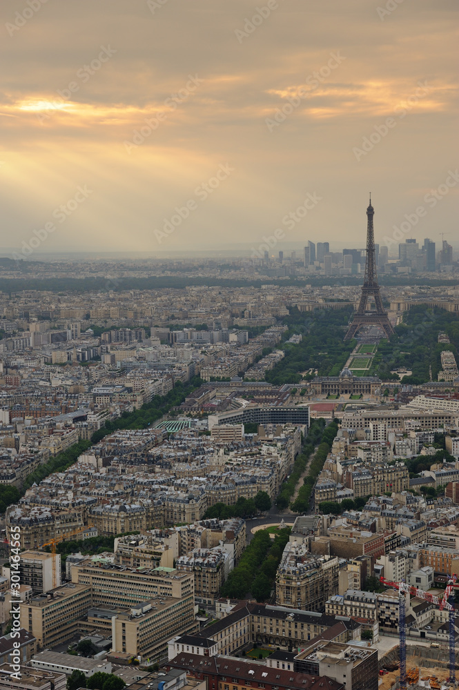 Aerial view of Paris, France. Eiffel tower in overcast sky with light rays. Polluted, dramatic ambience. Cranes in foreground