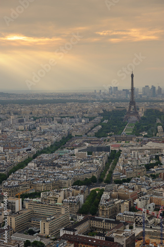 Aerial view of Paris, France. Eiffel tower in overcast sky with light rays. Polluted, dramatic ambience. Cranes in foreground © trialartinf