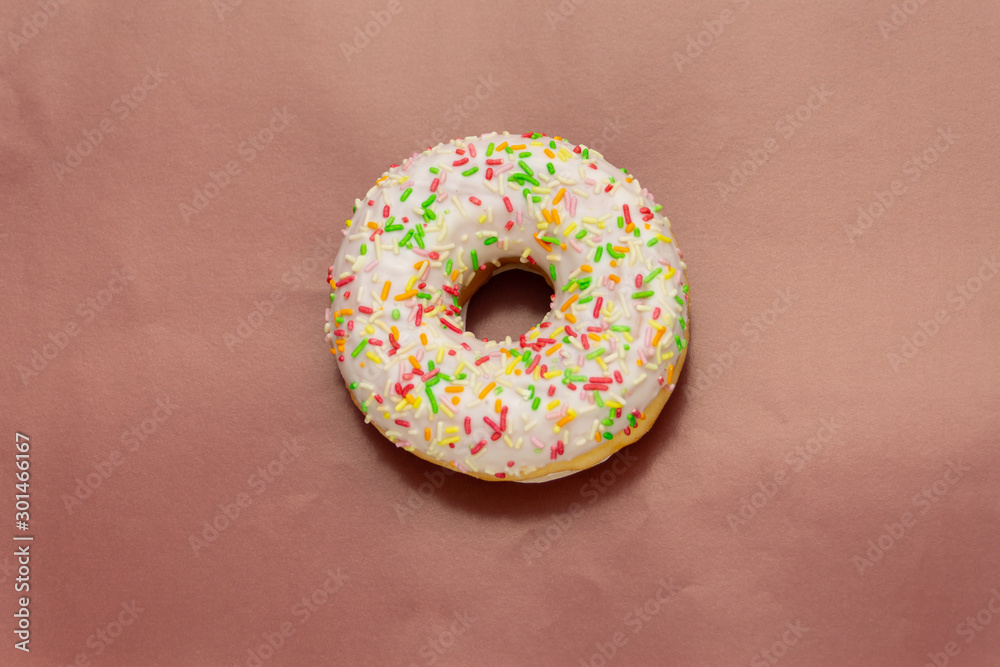 donut with colored sugar sprinkles on brown background donut with colored sugar sprinkles on brown background