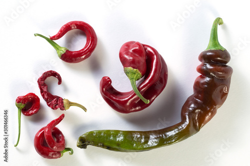 Fotografía Red, chili peppers of different shapes and sizes lie on a white background