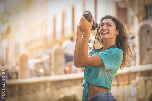 Girl tourist on vacation in Verona taking pictures, Italy, in front of the arena before the opera © Davide Marconcini