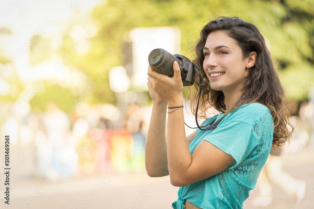 Smiling girl in an Italian city with a camera in her hand. Tourist or professional photographer