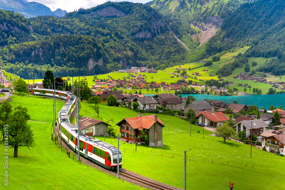 Famous electric red tourist panoramic train in swiss village Lungern, canton of Obwalden, Switzerland - obrazy, fototapety, plakaty 