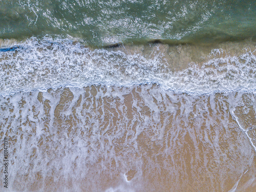 Drone picture of waves hitting the beach.