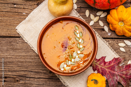Autumn pumpkin cream soup. Traditional ingredients, healthy food concept. Napkin, vintage wooden background