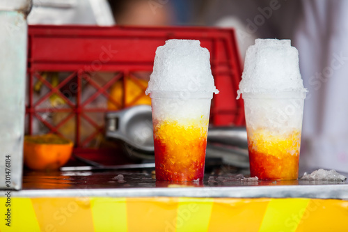 Street vendor in the city of Cali in Colombia preparing and selling a traditional sweet water ice called cholado photo