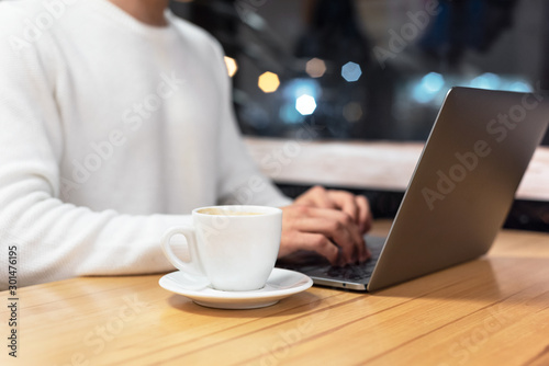 Close Up Of Man With Laptop And Coffee Cup At coffee shop .