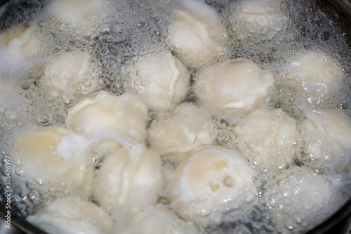 Dumplings in boiling water. Meat dumplings are boiled in a pot of boiling water.