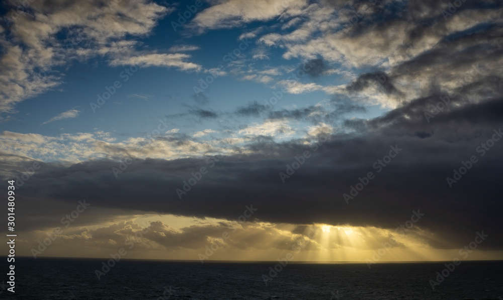 A sunrise produces shafts of light that trace across the Atlantic Ocean off the Cornish coast England,UK