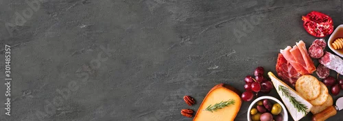 Panel kuchenny z motywem Selection of cheese and meat appetizers. Corner border banner, above view on a slate stone background with copy space.