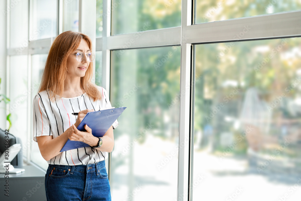 Portrait of stylish mature businesswoman near window in office Portrait of stylish mature businesswoman near window in office