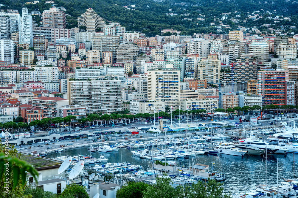 Fototapeta premium Monte Carlo, Monaco, 10/05/2019: A beautiful top view of the city marina with luxori yachts and the architecture of a rich city.